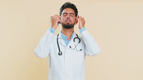 Tired Doctor Rubbing Eyes in White Lab Coat