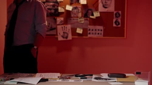 Detective's Office Middleaged Investigator in Shirt and Tie Studies Evidence in Search of the