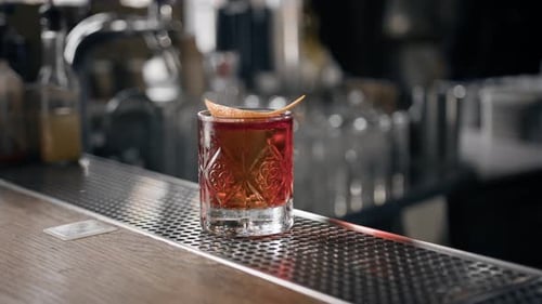 Close-up - Negroni cocktail ready stands on bar and waits for the guest