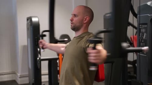 Athlete Bodybuilder Pumping Muscles in the Gym Flattens the Chest Muscles in the Trainer