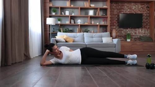 Woman Doing Leg Lifts on a Mat Indoors