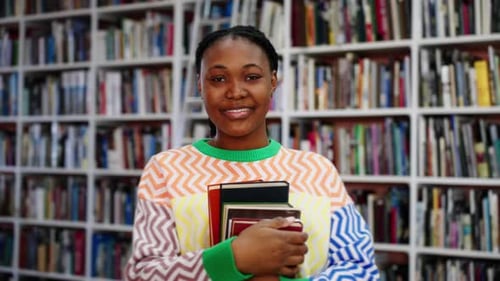 Portrait of African American Female Student with Books in the Library