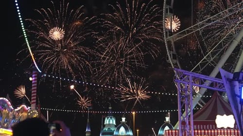 Fireworks show in Dubai Global Village attraction park with ferris wheel in the background at night