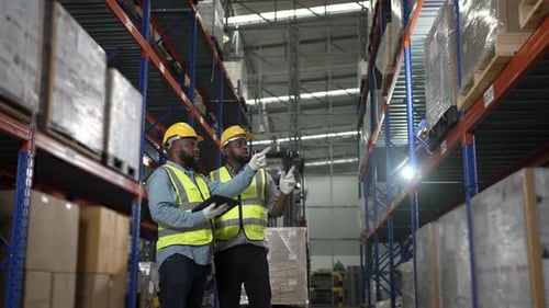 Blue collar workers are working at warehouse.