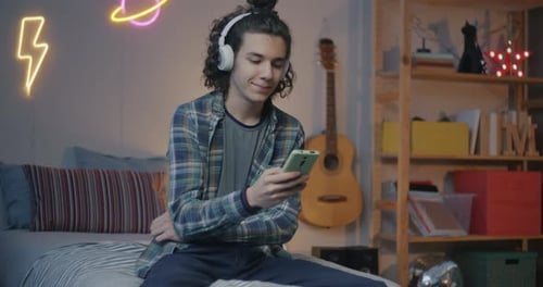 Young Adult Using Phone in Bedroom