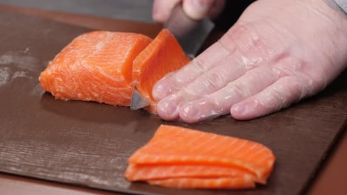 Chef Slices Salmon on Cutting Board for Food Prep