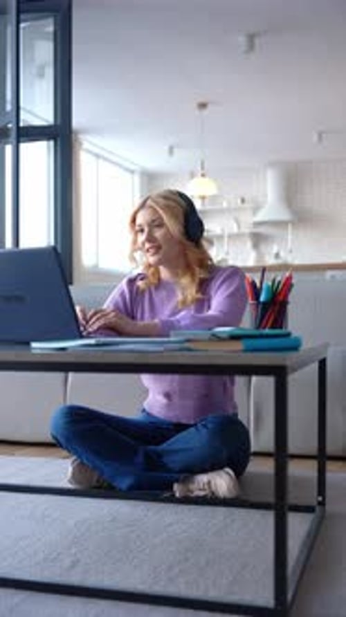 Smart Female High School Student in Headphones Homeschooling Online at Home