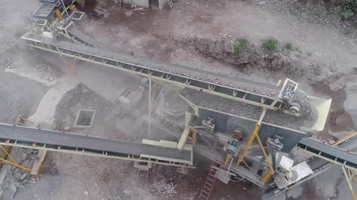Industriemaschine, die in einem Steinbruch Gestein zu verschiedenen Arten von Kies und Sand zerkleinert - Luftbild