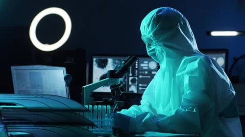 Scientist Works at Microscope in Futuristic Lab