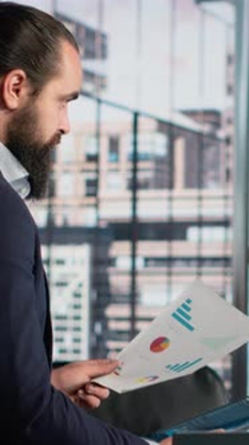Vertical Video Male Professional Reviewing Company Data Insights on Documents