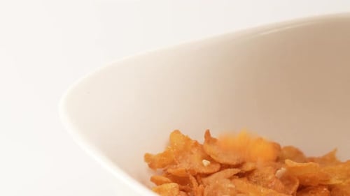 Crunchy Cornflakes Poured into a White Bowl