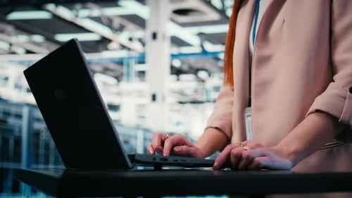 Close Up of Engineer Typing on Laptop in Server Farm