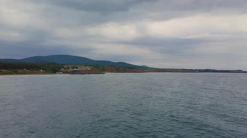 Drone flying above sea to the beach in winter