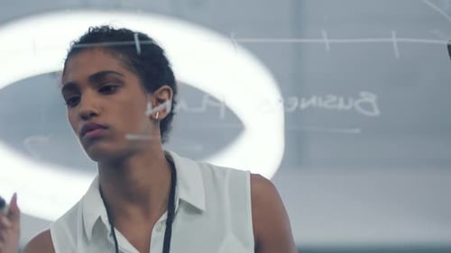 Woman Creating Business Plan on Glass Board