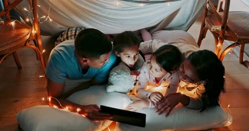 Happy Family in Pillow Fort Looks at Tablet