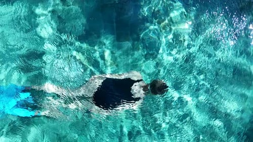 A Top View of a Swimmer in a Clear Blue Swimming Pool with Flippers Enjoying a Leisurely in Bali