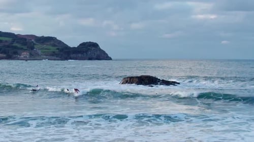 drone footage in slow motion of surfers on the ocean waves. wide view