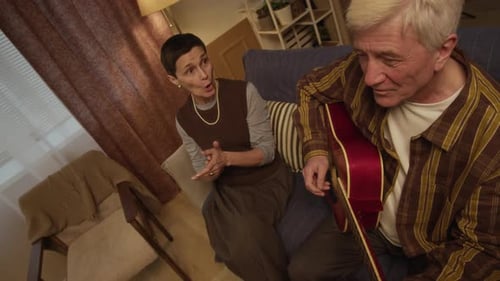 Senior Couple Relaxing, Man Playing Guitar for Woman