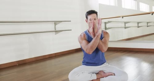 Focused caucasian man practicing yoga in gym, slow motion