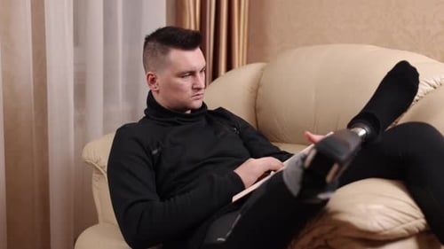 Man With Prosthetic Leg Reading a Book