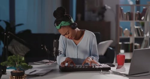 Young Adult Plays Keyboard in Home Recording Studio