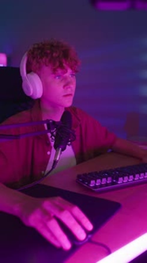 Young Adult Gaming on Computer in Purple Room