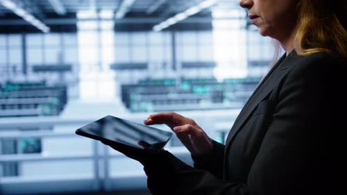 Woman Uses Tablet in Futuristic Server Room