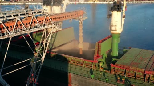 Aerial of Wheat Loading to Bulker Ship Cargo Hold at Sea Grain Elevator in Sea Port Wheat Pouring