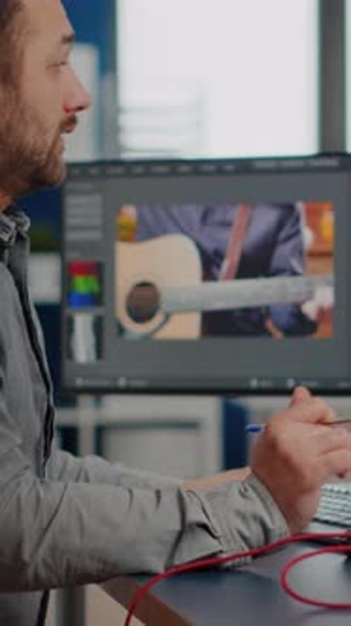 Man Editing Video Footage in Office