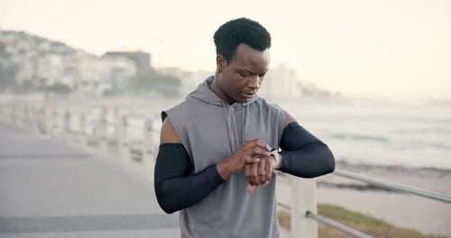 Black man, check and smart watch for fitness at beach for heart rate, exercise and monitor progress