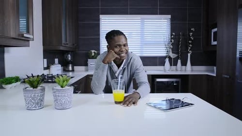 Smiling Young Man Relaxing in Modern Kitchen