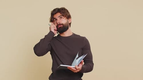 Man Writing in Notebook Having Idea Moment