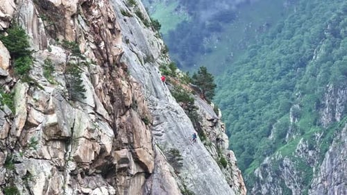 Two Climbers Make Their Way Up a Steep Mountain Face