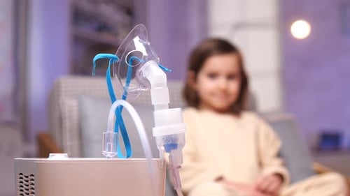 Nebulizer Dispenses Mist with Child in Background