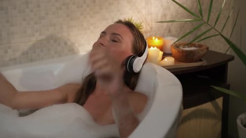 Woman Relaxes in Bubble Bath with Headphones