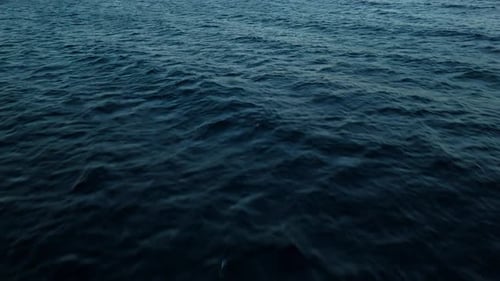 Mysterious dark blue ocean water of the deep sea with textured current ripples