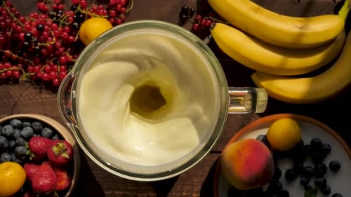 Top View Slow Mixing Milkshake with Yellow Banana Flavor Grind Fruits with Milk Using a Blender and