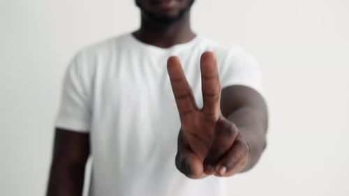 Person Shows Peace Sign on White Background