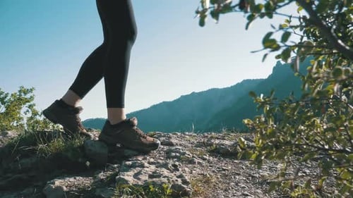 View on Feet of Traveler Woman Hiking Walking on the Top of Cliff in Mountain Walking on Rocks