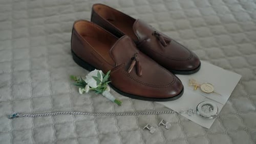 Groom's Accessories Arranged on a Patterned Bed