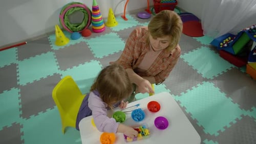 Child Learning Sorting Skills With Adult Assistant