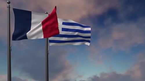 French and Uruguayan Flags Waving Against Cloudy Sky