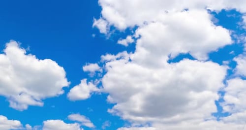 Beautiful azure summer sky with white clouds quickly changing shape. Low angle view timelapse.