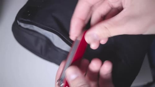 Hands Close Black Bag with a Pocket Knife