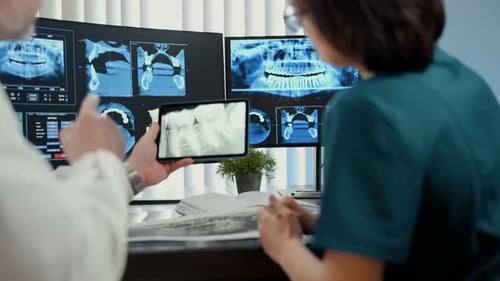 Doctors are Analyzing Teeth MRI CT Scan Image and Multiple Monitors Stands in Modern Clinic Advanced