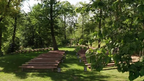 Aerial, empty outdoor forest wedding ceremony venue during the day with no one