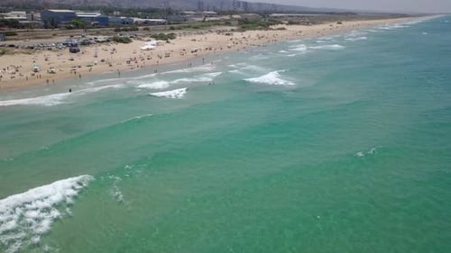 Beautiful sandy beach with people and colourful umbrellas - Aerial footage