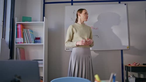 Woman Explains Math Equations in Classroom Setting