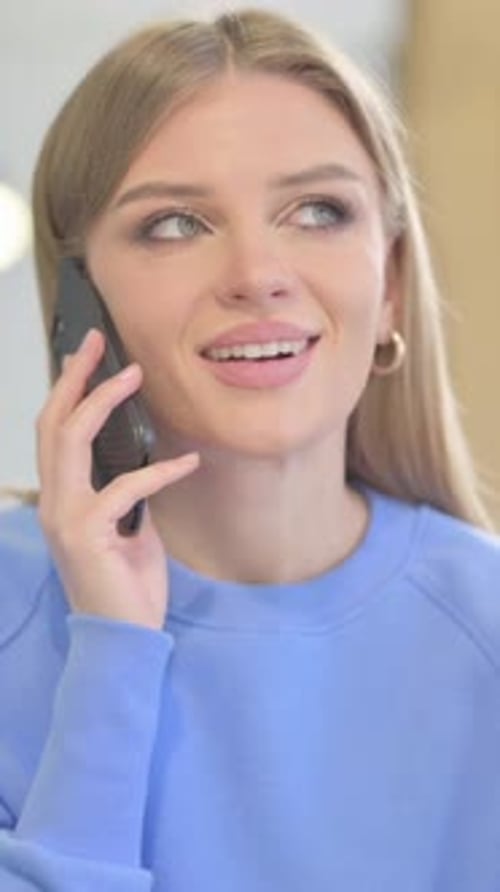 Young Woman Talking on Mobile Phone Indoors
