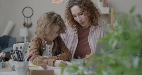 Woman Helps Child with Homework at Home